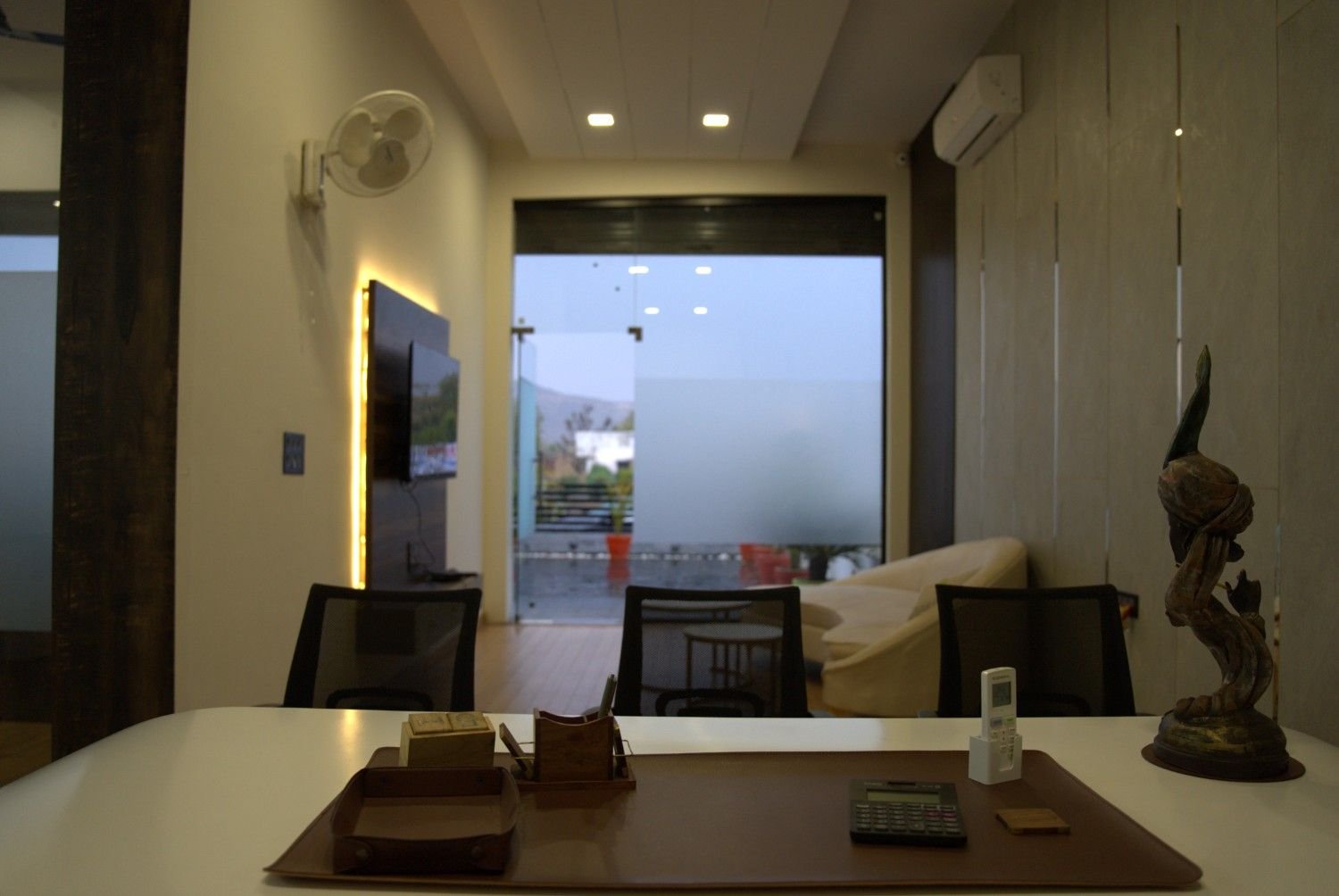 Director cabin dark panel glass partition backlit TV wall — Loanplex corporate office interior Jaipur