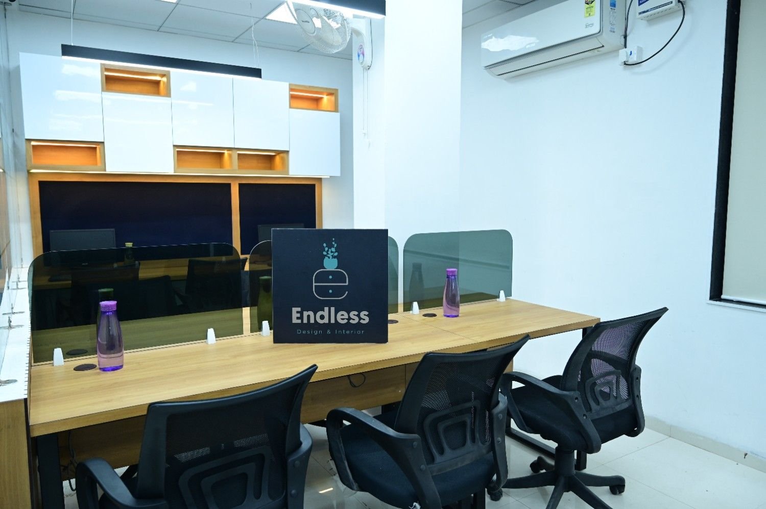 Open workstation layout office interior Kota — multiple rows wood desks by Endless Interiors and Construction