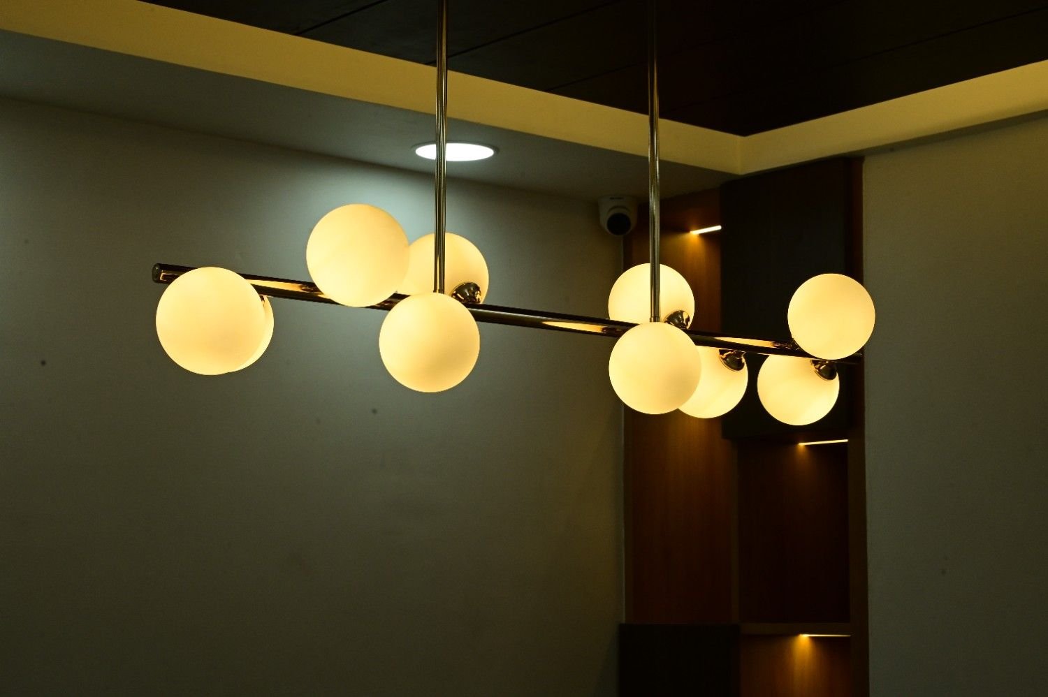 Globe chandelier warm wood panel ceiling detail office interior Kota — Endless Interiors and Construction